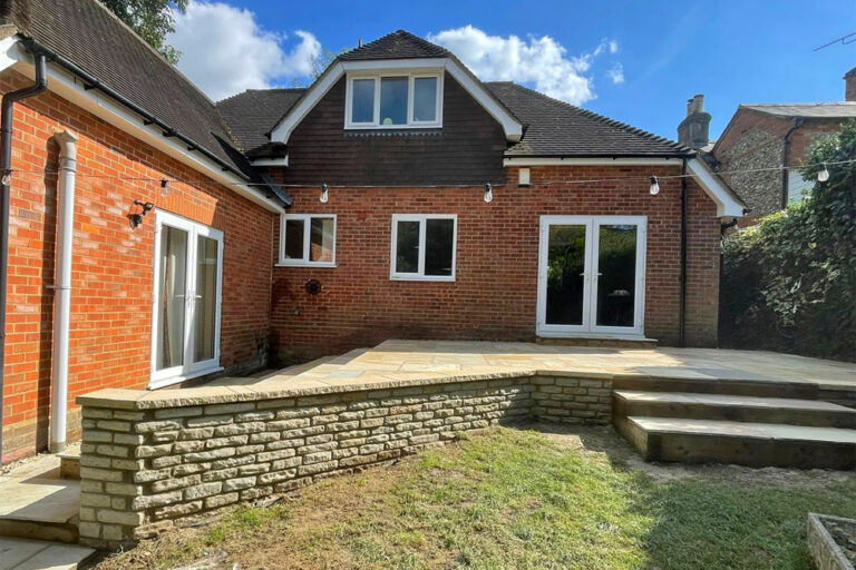 View of wall from lawn Indian Sandstone Patio. The New Driveway Company