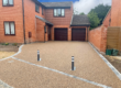 Large resin driveway going up to garage with bollards