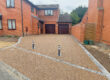 Large resin driveway going up to garage with bollards