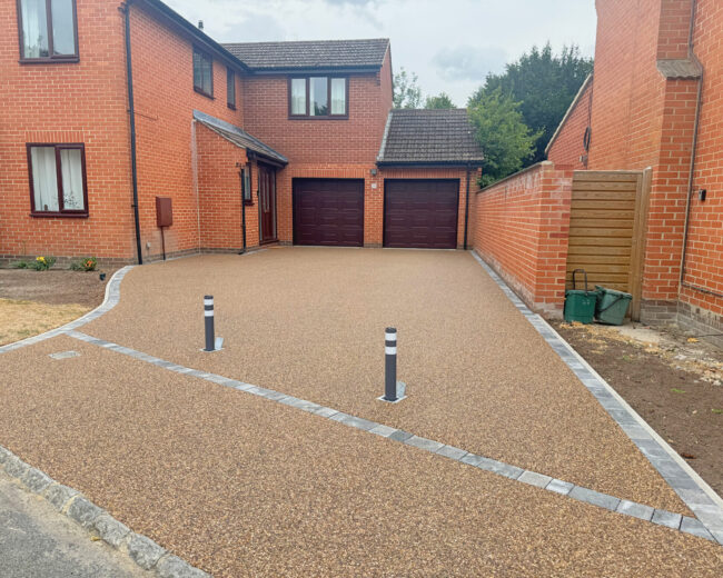 Large resin driveway going up to garage with bollards